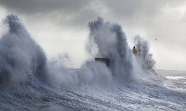 Завораживающие кадры штормовых волн, обрушившихся на маяк. Фото